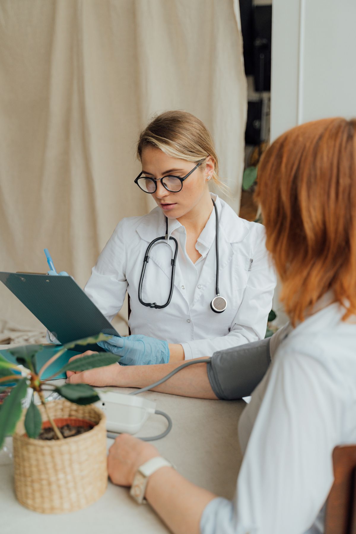 A doctor checking a patient’s blood pressure during a consultation